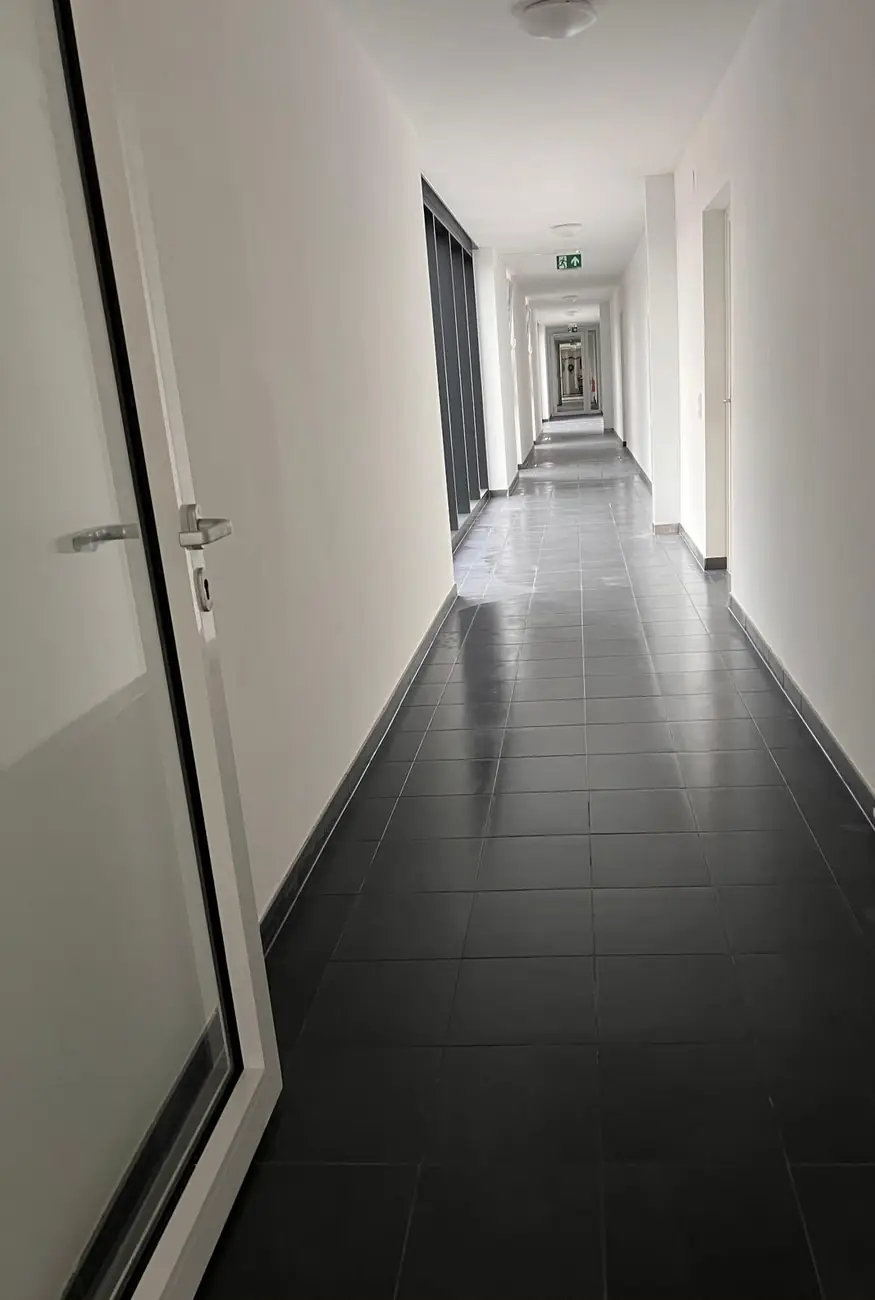 Langer Gang mit Fliesenboden nach der Reinigung